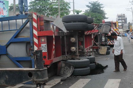 A container truck tumbled onto the street while driving down Hoang Dieu 2 Street in Thu Duc District on October 12 after a section of road collapsed three meters into the ground (Photo: TN) A container truck tumbled onto the street while driving down Hoang Dieu 2 Street in Thu Duc District on October 12 after a section of road collapsed three meters into the ground (Photo: TN)