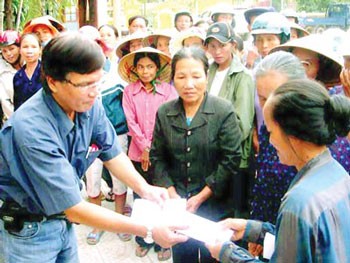 A representative of the Sai Gon Giai Phong Newspaper (L) presents cash relief to flood victims in Le Thuy District, Quang Binh Province. A representative of the Sai Gon Giai Phong Newspaper (L) presents cash relief to flood victims in Le Thuy District, Quang Binh Province.