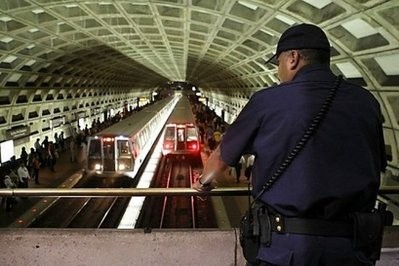 A Metro Transit police officer watches Metro trains arrive at the Gallery Place - Chinatown Station in Washington, DC. A Metro Transit police officer watches Metro trains arrive at the Gallery Place - Chinatown Station in Washington, DC.
