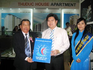HUBA chairman Huynh Van Minh (L) presents a certificate of merits to a representative of Thu Duc House Corp. at the fair on Nov. 3. Thu Duc House is among companies receiving the certificates for their substantial contributions to the city’s development this year. (Photo: Tuong Thuy) HUBA chairman Huynh Van Minh (L) presents a certificate of merits to a representative of Thu Duc House Corp. at the fair on Nov. 3. Thu Duc House is among companies receiving the certificates for their substantial contributions to the city’s development this year. (Photo: Tuong Thuy)
