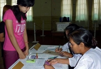 A Myanmar voter (L) has her documents checked by officials before casting her vote. A Myanmar voter (L) has her documents checked by officials before casting her vote.
