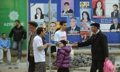 Party workers hand out leaflets on a street in Baku. Party workers hand out leaflets on a street in Baku.