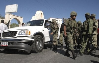 Soldiers stand next to a vehicle during a gunfight with alleged cartel members in the northern border city of Matamoros, Mexico, Friday Nov. 5, 2010. Soldiers stand next to a vehicle during a gunfight with alleged cartel members in the northern border city of Matamoros, Mexico, Friday Nov. 5, 2010.