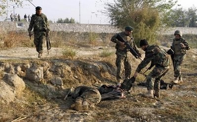 An Afghan National Army soldiers pulls the vest from the body of a suspected Taliban fighter, disguised as an Afghan National Army solider, following an attack on the Jalalabad military air base in Jalalabad, east of Kabul, Afghanistan, Saturday, Nov 12. An Afghan National Army soldiers pulls the vest from the body of a suspected Taliban fighter, disguised as an Afghan National Army solider, following an attack on the Jalalabad military air base in Jalalabad, east of Kabul, Afghanistan, Saturday, Nov 12.