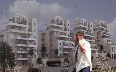 An Israeli man speaks on his mobile phone as he walks past an advertising sign for a new housing project in the Jewish settlement of Har Homa in east Jerusalem. An Israeli man speaks on his mobile phone as he walks past an advertising sign for a new housing project in the Jewish settlement of Har Homa in east Jerusalem.