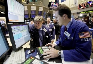 In this Nov. 11, 2010 photo, specialist Glenn Carell, right, works at his post on the floor of the New York Stock Exchange In this Nov. 11, 2010 photo, specialist Glenn Carell, right, works at his post on the floor of the New York Stock Exchange