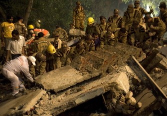 Indian relief workers lift rubble early on November 16, 2010 on the site where the building collapsed. AFP Indian relief workers lift rubble early on November 16, 2010 on the site where the building collapsed. AFP