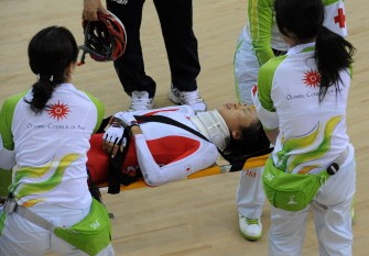 Injured rider Mayuko Hagiwara of Japan wears a neck brace as she is carried from the track on a stretcher after crashing heavily in the women's points race cycling. AFP Injured rider Mayuko Hagiwara of Japan wears a neck brace as she is carried from the track on a stretcher after crashing heavily in the women's points race cycling. AFP