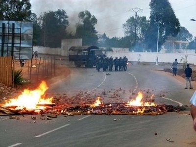 Madagascan forces stand at a distance from a burning barricade in a road leading to Antananarivo's International airport. Madagascan forces stand at a distance from a burning barricade in a road leading to Antananarivo's International airport.