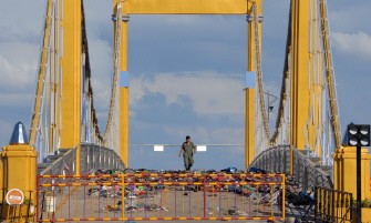 A policeman walks among clothes, shoes and personal belongings left on the Diamond Gate Bridge by the victims of the stampede in Phnom Penh on November 23, 2010. AFP A policeman walks among clothes, shoes and personal belongings left on the Diamond Gate Bridge by the victims of the stampede in Phnom Penh on November 23, 2010. AFP