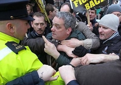 An Irish policeman (L) is confronted by protestors as they break through the front gates of the Irish Prime Minister's office in Dublin, Ireland. An Irish policeman (L) is confronted by protestors as they break through the front gates of the Irish Prime Minister's office in Dublin, Ireland.