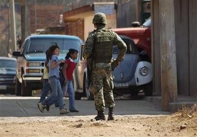 A soldier stands guard as girls walk past in Morelia November 24, 2010 A soldier stands guard as girls walk past in Morelia November 24, 2010