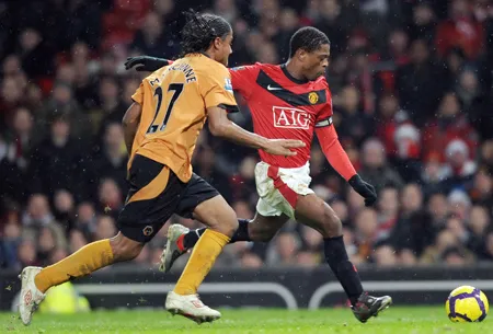 Hậu vệ Man.United Patrice Evra (phải) sút bóng trước Michael Mancienne của Wolves Hậu vệ Man.United Patrice Evra (phải) sút bóng trước Michael Mancienne của Wolves