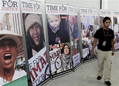 A man walks past posters reading Time for Climate Justice in Cancunmesse, where climate talks are taking place, in Cancun December 2, 2010. A man walks past posters reading Time for Climate Justice in Cancunmesse, where climate talks are taking place, in Cancun December 2, 2010.