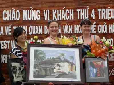 The four millionth visitor, Amelia (C), receives a gift from the Hoi An authority
