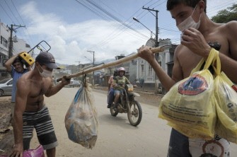 Wearing protective masks due to the stench, local residents attempt to salvage goods on a street severely damaged by the recent floods in Nova Friburgo, Rio de Janeiro, Brazil, on January 17, 2011. AFP Wearing protective masks due to the stench, local residents attempt to salvage goods on a street severely damaged by the recent floods in Nova Friburgo, Rio de Janeiro, Brazil, on January 17, 2011. AFP