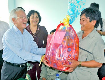 Le Hoang Quan (L), chairman of the Ho Chi Minh City People's Committee, visits and gives a Tet gift to a resident in the city's Can Gio District Le Hoang Quan (L), chairman of the Ho Chi Minh City People's Committee, visits and gives a Tet gift to a resident in the city's Can Gio District