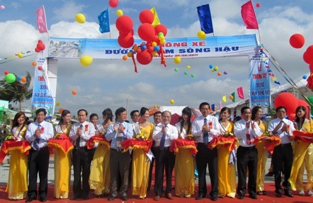 Deputy PM Nguyen Sinh Hung (8th from R) cuts the ribbon to open South Hau River road (Photo:VGP) Deputy PM Nguyen Sinh Hung (8th from R) cuts the ribbon to open South Hau River road (Photo:VGP)
