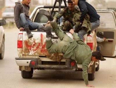 A fleeing Libyan rebel falls from a truck driving back to the coastal city of Benghazi. AFP A fleeing Libyan rebel falls from a truck driving back to the coastal city of Benghazi. AFP
