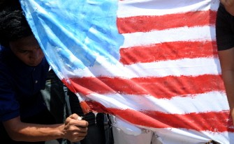 Student activists burn a US flag outside the gates of the US embassy in the Philippines' Manila on March 22, 2011, condemning the Western air assault on Libya. Student activists burn a US flag outside the gates of the US embassy in the Philippines' Manila on March 22, 2011, condemning the Western air assault on Libya.