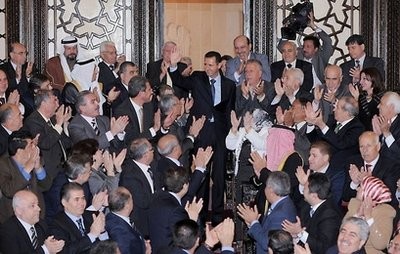 AFP - A handout picture released by the Syrian Arab News Agency (SANA) shows Syrian President Bashar al-Assad (C) waving as parliament members applaud in Damascus. AFP - A handout picture released by the Syrian Arab News Agency (SANA) shows Syrian President Bashar al-Assad (C) waving as parliament members applaud in Damascus.
