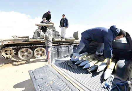 Phe nổi dậy tiếp nhận vũ khí tại thành phố Ajdabiya. Ảnh: AFP Phe nổi dậy tiếp nhận vũ khí tại thành phố Ajdabiya. Ảnh: AFP
