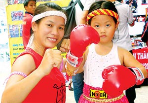 Ngoc Linh (left, in red) poses with a children fan (Photo:SGGP) Ngoc Linh (left, in red) poses with a children fan (Photo:SGGP)