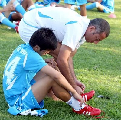 HLV Giullaume chỉ dẫn học trò mang giày đá thử.