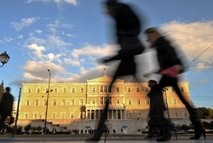 AFP/File – File photo shows people walking past the Greek Parliament in Athens. AFP/File – File photo shows people walking past the Greek Parliament in Athens.