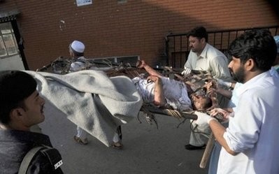 Pakistani men carry an injured blast victim to a hospital in Peshawar on May 13, 2011 following a suicide and bomb attack on the paramilitary police in the northwestern Charsadda district Pakistani men carry an injured blast victim to a hospital in Peshawar on May 13, 2011 following a suicide and bomb attack on the paramilitary police in the northwestern Charsadda district