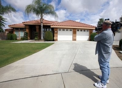 Stephen Coleman, a cameraman for ABC News, photographs the home believed to be the residence of a household staff member who mothered a child with former Gov. Arnold Schwarzenegger, Wednesday, May 18, 2011, in Bakersfield, Calif Stephen Coleman, a cameraman for ABC News, photographs the home believed to be the residence of a household staff member who mothered a child with former Gov. Arnold Schwarzenegger, Wednesday, May 18, 2011, in Bakersfield, Calif
