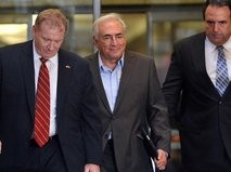 AFP/File – Former IMF head Dominique Strauss-Khan (C) leaves his temporary house under guard in New York AFP/File – Former IMF head Dominique Strauss-Khan (C) leaves his temporary house under guard in New York