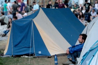 AFP - A man looks out from his tent during a demonstration in front of White Tower in Thessaloniki, on May 27, 2011. AFP - A man looks out from his tent during a demonstration in front of White Tower in Thessaloniki, on May 27, 2011.