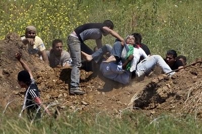 Demonstrators prepare to evacuate a wounded fellow protestor who was hit by Israeli fire while trying to cut through a line of barbed wire and head into the Israeli-annexed Golan Heights Demonstrators prepare to evacuate a wounded fellow protestor who was hit by Israeli fire while trying to cut through a line of barbed wire and head into the Israeli-annexed Golan Heights
