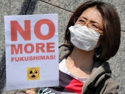 A protester holds a placard during a rally denouncing nuclear power in front of the headquarters of Tokyo Electric Power Company. A protester holds a placard during a rally denouncing nuclear power in front of the headquarters of Tokyo Electric Power Company.