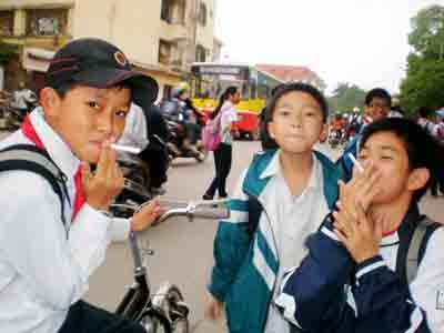 Secondary school children trying out cigarette-shaped sweets from street vendors in their campus (Photo: SGGP) Secondary school children trying out cigarette-shaped sweets from street vendors in their campus (Photo: SGGP)
