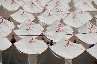 AFP - Syrian refugees walk past tents at the Boynuyogun Turkish Red Crescent camp in the Altinozu district of Hatay, near the Syrian border, on June 12, 2011. AFP - Syrian refugees walk past tents at the Boynuyogun Turkish Red Crescent camp in the Altinozu district of Hatay, near the Syrian border, on June 12, 2011.