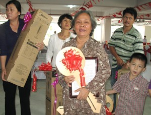 Vo Thi Dung, 60, holds a token key for her new apartment during the key handover ceremony on June 18, 2011. Her electric fan gift is just behind.(Photo: Tuong Thuy) Vo Thi Dung, 60, holds a token key for her new apartment during the key handover ceremony on June 18, 2011. Her electric fan gift is just behind.(Photo: Tuong Thuy)