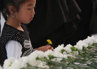 AFP - A girl places a chrysanthemum on an altar to offer prayers at a ceremony to mark 100 days since the March 11 massive earthquake which killed over 15,000 people at Ishinomaki city in Miyagi prefecture on June 18, 2011. AFP - A girl places a chrysanthemum on an altar to offer prayers at a ceremony to mark 100 days since the March 11 massive earthquake which killed over 15,000 people at Ishinomaki city in Miyagi prefecture on June 18, 2011.