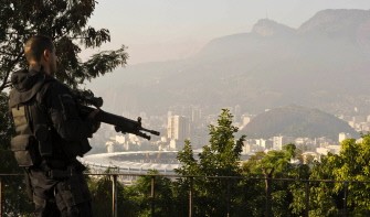 AFP – A riot soldier secures a point at Rio de Janeiro's Morro da Mangueira shantytown above Maracana stadium during a pre-announced operation in the slum, early in the morning of June 19, 2011. AFP – A riot soldier secures a point at Rio de Janeiro's Morro da Mangueira shantytown above Maracana stadium during a pre-announced operation in the slum, early in the morning of June 19, 2011.