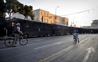 AFP - Cyclists ride past a police blockade as Greek 'Indignants' protest for the fourth consecutive week against new austerity measures in front of the Greek parliament, in the central Syntagma square of Athens, on June, 19, 2011. AFP - Cyclists ride past a police blockade as Greek 'Indignants' protest for the fourth consecutive week against new austerity measures in front of the Greek parliament, in the central Syntagma square of Athens, on June, 19, 2011.