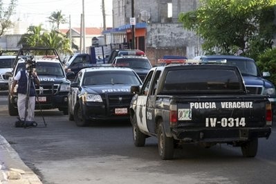 A cameraman stands next to police vehicles parked outside the home of journalist Miguel Angel Lopez Velasco in the Gulf Coast city of Veracruz, Mexico, Monday June 20, 2011. A cameraman stands next to police vehicles parked outside the home of journalist Miguel Angel Lopez Velasco in the Gulf Coast city of Veracruz, Mexico, Monday June 20, 2011.
