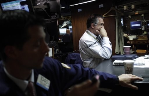 In this June 27, 2011 photo, traders work on the floor at the New York Stock Exchange in New York. In this June 27, 2011 photo, traders work on the floor at the New York Stock Exchange in New York.