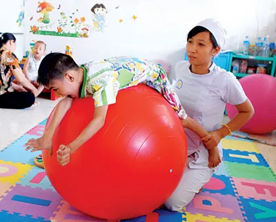 Tập cơ lưng, cơ bụng trên quả bóng giúp trẻ bị bại não có thể đi đứng tốt Tập cơ lưng, cơ bụng trên quả bóng giúp trẻ bị bại não có thể đi đứng tốt