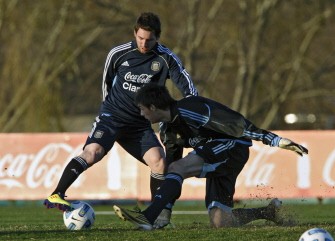 AFP - Lionel Messi (L) controls the ball past a sparring during a training session of the national football team in Ezeiza, Buenos Aires on June 27, 2011 AFP - Lionel Messi (L) controls the ball past a sparring during a training session of the national football team in Ezeiza, Buenos Aires on June 27, 2011