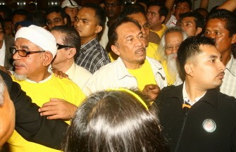 AFP - Malaysian opposition leader Anwar Ibrahim (C) and President of the Parti Islam SeMalaysia (PAS) Hadi Awang (L) are surrounded by supporters after holding a press conference during a mass rally calling for electoral reform in Kuala Lumpur on July 9, 2011. AFP - Malaysian opposition leader Anwar Ibrahim (C) and President of the Parti Islam SeMalaysia (PAS) Hadi Awang (L) are surrounded by supporters after holding a press conference during a mass rally calling for electoral reform in Kuala Lumpur on July 9, 2011.