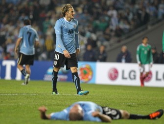 AFP - Diego Forlan(10) walks towards his teammate Diego Perez (on the field) after the team missed a goal AFP - Diego Forlan(10) walks towards his teammate Diego Perez (on the field) after the team missed a goal
