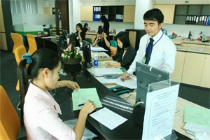 A woman fills credit application forms at a HCMC-based bank. Businesses still struggle to cope with capital shortage as lending rate remain high (Photo: Minh Tri) A woman fills credit application forms at a HCMC-based bank. Businesses still struggle to cope with capital shortage as lending rate remain high (Photo: Minh Tri)