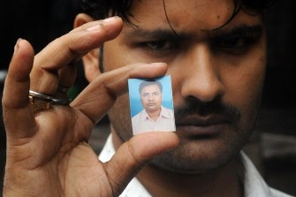 AFP - Indian mourner Mahant Mandal holds a photograph of his brother Kishan Mandal after his death in a bomb blast in Mumbai on July 14, 2011. AFP - Indian mourner Mahant Mandal holds a photograph of his brother Kishan Mandal after his death in a bomb blast in Mumbai on July 14, 2011.