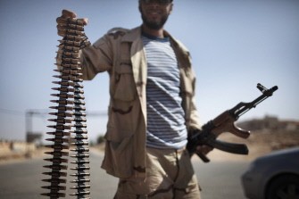 A Libyan rebel holds a bullet belt at the Western gate of the front line town of Ghualish July 12, 2011. A Libyan rebel holds a bullet belt at the Western gate of the front line town of Ghualish July 12, 2011.